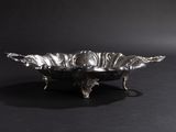 a silver plate with a bird on it on a black background