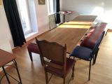 a long wooden table with four chairs in a room