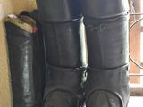 une paire de bottes noires posées sur le sol à côté d'une fenêtre