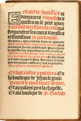 un vieux livre sur lequel figurent des inscriptions en noir et rouge