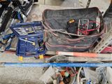 a bag of tools sitting on the floor next to tools