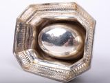 a silver object that is sitting on a white surface