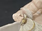 a figurine of a man holding a fan in a bowl