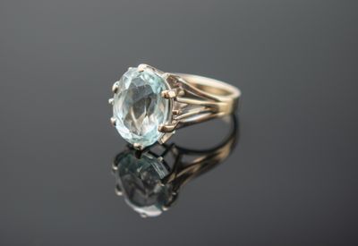Gros plan sur une bague en or ornée d'une topaze bleue