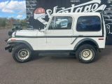 a picture of a white jeep parked in front of a sign