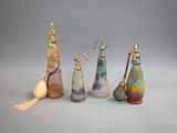Plusieurs bouteilles en verre de différentes couleurs sont alignées sur une surface grise.