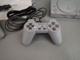 a white game controller sitting on a table next to a box