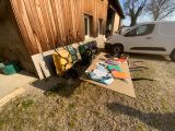une camionnette blanche garée à côté d'un immeuble, avec tout un tas d'objets par terre