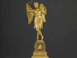 statue en or représentant un ange tenant un arc et une flèche à la main