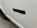 a close up of a white car with a sticker on it