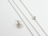 a close up of a necklace and a chain on a white surface