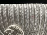 a close up of a white purse with a knot on it
