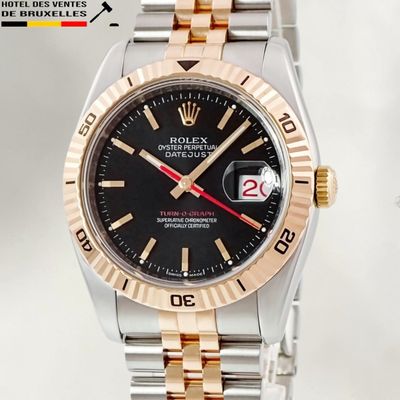 a rolex watch with a black dial on a gold bracelet
