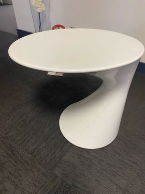 une image représentant une table blanche sur laquelle est posée une fleur