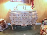 a dresser and chair in a room with a lamp on