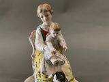 a figurine of a woman with a child and a dog
