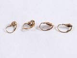 four gold rings are shown in a row on a white surface