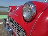 une voiture rouge garée sur le bord de la route