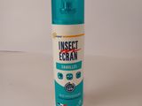 a close up of a bottle of insect cream on a white surface