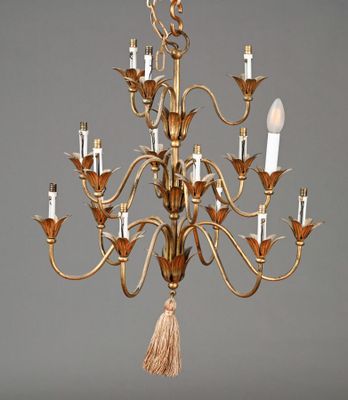 an antique brass chandelier with five lights and a tassel hanging from the ceiling