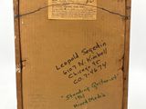 an old wooden box with writing on it sitting on a white surface