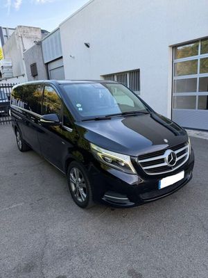 une camionnette noire garée devant un immeuble blanc