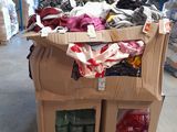 une boîte en carton sur laquelle sont posés des vêtements, dans un entrepôt