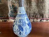 a blue and white vase sitting on a wooden table