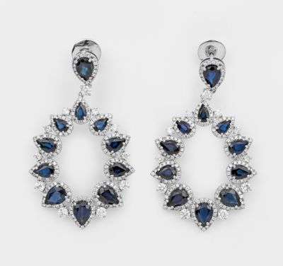 une paire de boucles d'oreilles en saphir et diamants sur fond blanc