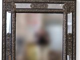 un miroir accroché au mur dans lequel se reflète une personne