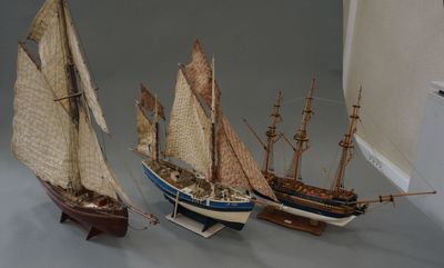 three model ships that are on display on a table