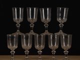 six wine glasses sitting on a table with a black background