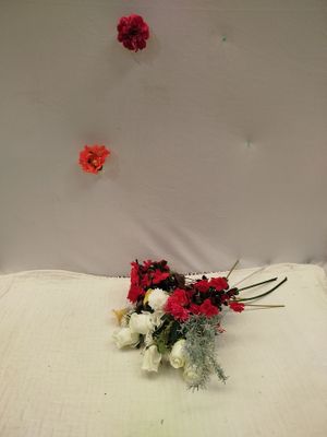 un bouquet de fleurs rouges et blanches posé sur un lit