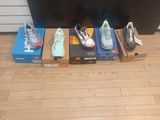 several pairs of shoes are lined up on the floor in front of a flat screen tv