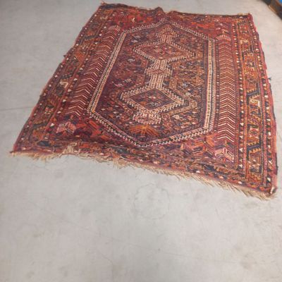 un tapis posé au sol, au milieu d'une pièce où se trouve une chaise