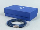 un gros plan sur une boîte bleue sur laquelle est posé un bracelet
