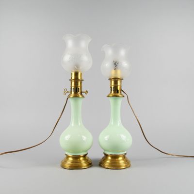 une paire de lampes en verre vert avec des ferrures en laiton