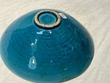 a blue vase that has a gold ring on it