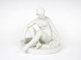 une image représentant une statue blanche d'une femme assise sur une table