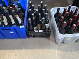 many bottles of wine in plastic containers on the floor