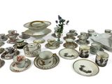 many different types of porcelain dishes and cups on the table