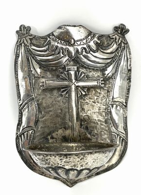 an antique silver plate with a cross on it on a white background