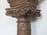 a close up of a wooden column with a clock on it