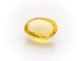 a yellow sapphire stone on a white background