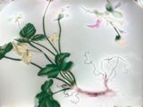 a white plate with flowers and leaves painted on it
