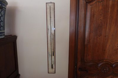 un thermomètre fixé au mur, à côté d'une armoire