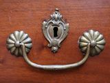 a wooden drawer with a metal handle and a keyhole