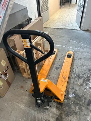 une palette posée par terre à côté d'une pile de cartons