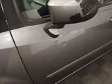 a side view mirror of a car with a reflection of a building