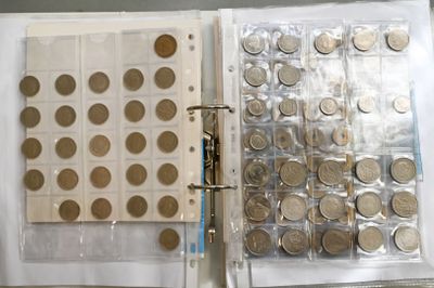 a binder full of coins sitting on top of a table